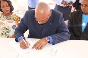 Mr. Keith “Dis an Dat” Scarborough, candidate for the Constituency Nevis 5, St. Thomas’ Parish by-election signs the Statutory Declaration of a Person Nominated as a Candidate for Election as a Member of the Nevis Island Assembly on Nomination Day, February 25, 2020, at the Cotton Ground Community Centre, before Mrs. Sherilla Nisbett, Returning Officer for the Electoral District 5. He is flanked by his nominators (l) Ms. Shoya Matthew of Jessups Village and (r) Mr. Denzil Webbe of Cotton Ground