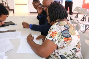 : Ms. Shoya Matthew of Jessups Village signs a Statutory Declaration of a Person Nominating a Candidate for Election as a Member of the Nevis Island Assembly on Nomination Day, February 25, 2020, for Mr. Keith “Dis an Dat” Scarborough of Cotton Ground, the representative for the Concerned Citizens Movement, in the March 05, 2020, by-election in District 5, St. Thomas’ Parish (Lowlands)