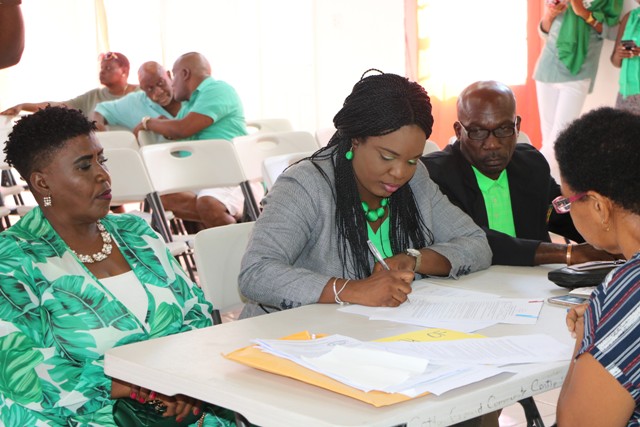 Mrs. Cleone Stapleton Simmonds candidate for the District 5, St. Thomas’ Parish by-election signs the Statutory Declaration of a Person Nominated as a Candidate for Election as a Member of the Nevis Island Assembly on Nomination Day, February 25, 2020, at the Cotton Ground Community Centre, before Mrs. Sherilla Nisbett, Returning Officer for the Electoral District 5. She is flanked by her nominators (l) Ms. Jenet Jennifer Jeffers; and (r) Mr. Collin Terrence Stapleton of Cotton Ground