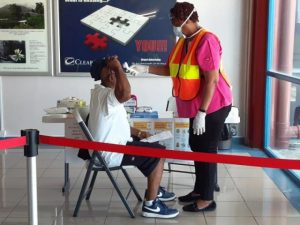 A nurse taking the temperature of a passenger on arrival at the Vance W. Amory International Airport as part of the Nevis Air and Sea Ports Authority’s enhanced security measures in response to the COVID-19 pandemic
