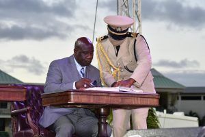 Hon. Alexis Jeffers, Deputy Premier of Nevis signs the official documents after taking his oath at the Inauguration Ceremony of the Team Unity Administration’s Second Term at Warner Park in Basseterre on June 14, 2020