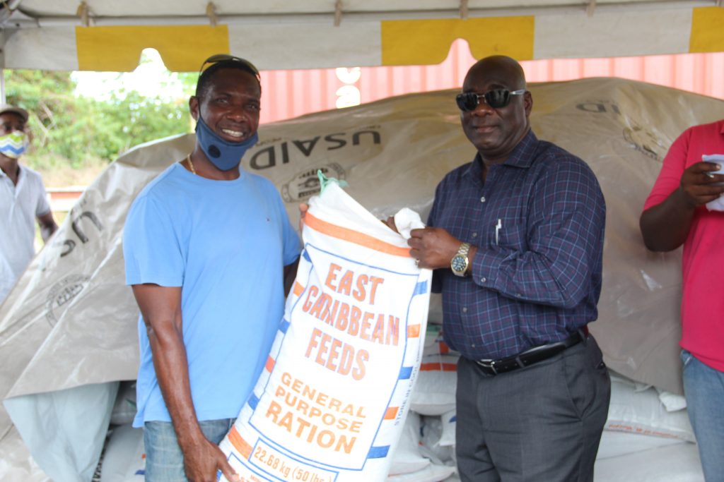 (L-r) Mr. Morris Hanley, one of 154 livestock farmers on Nevis receiving free animal feed in a Nevis Island Administration/Eastern Caribbean Group of Companies partnership from Hon. Alexis Jeffers, Deputy Premier of Nevis and Minister of Agriculture at Prospect on July 15, 2020