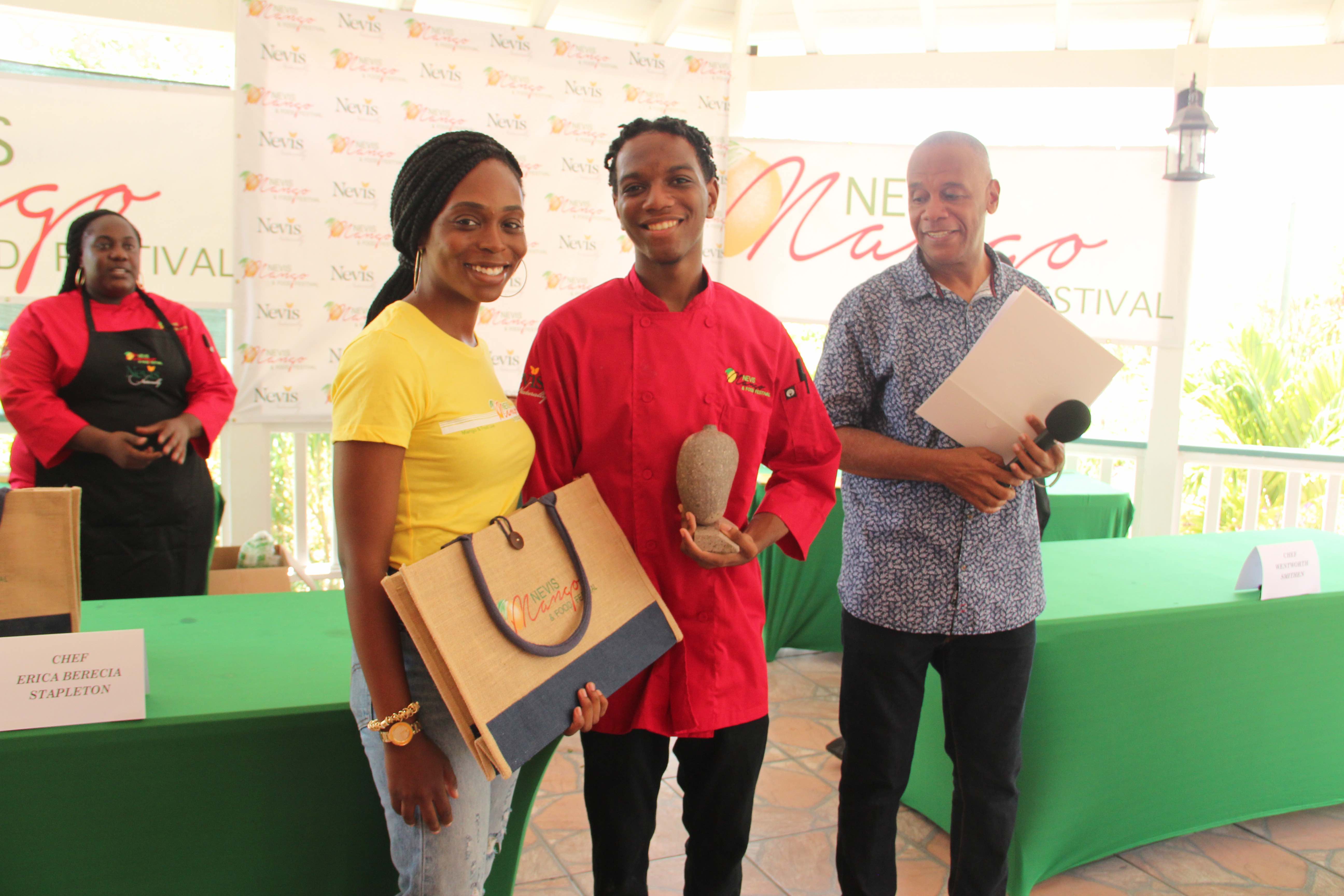(l-R) Ms. Jadine Yarde, Chief Executive Officer at the Nevis Tourism Authority with Chef Wentworth Smithen, winner of the Cook-Off at the Nevis Mango and Food Festival hosted by the Nevis Tourism Authority at Cleveland Gardens on July 04, 2020. Hon. Eric Evelyn, who served as the master of ceremony, and runner-up chef and culinary artist Erika Stapleton look on