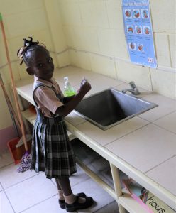 A Kindergarten student at the Charlestown Primary School learns proper hand washing technique