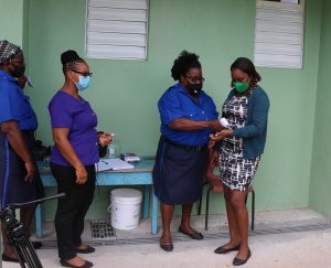 Staff at the entrance of the Charlestown Primary School checking the temperature of persons visiting the school    