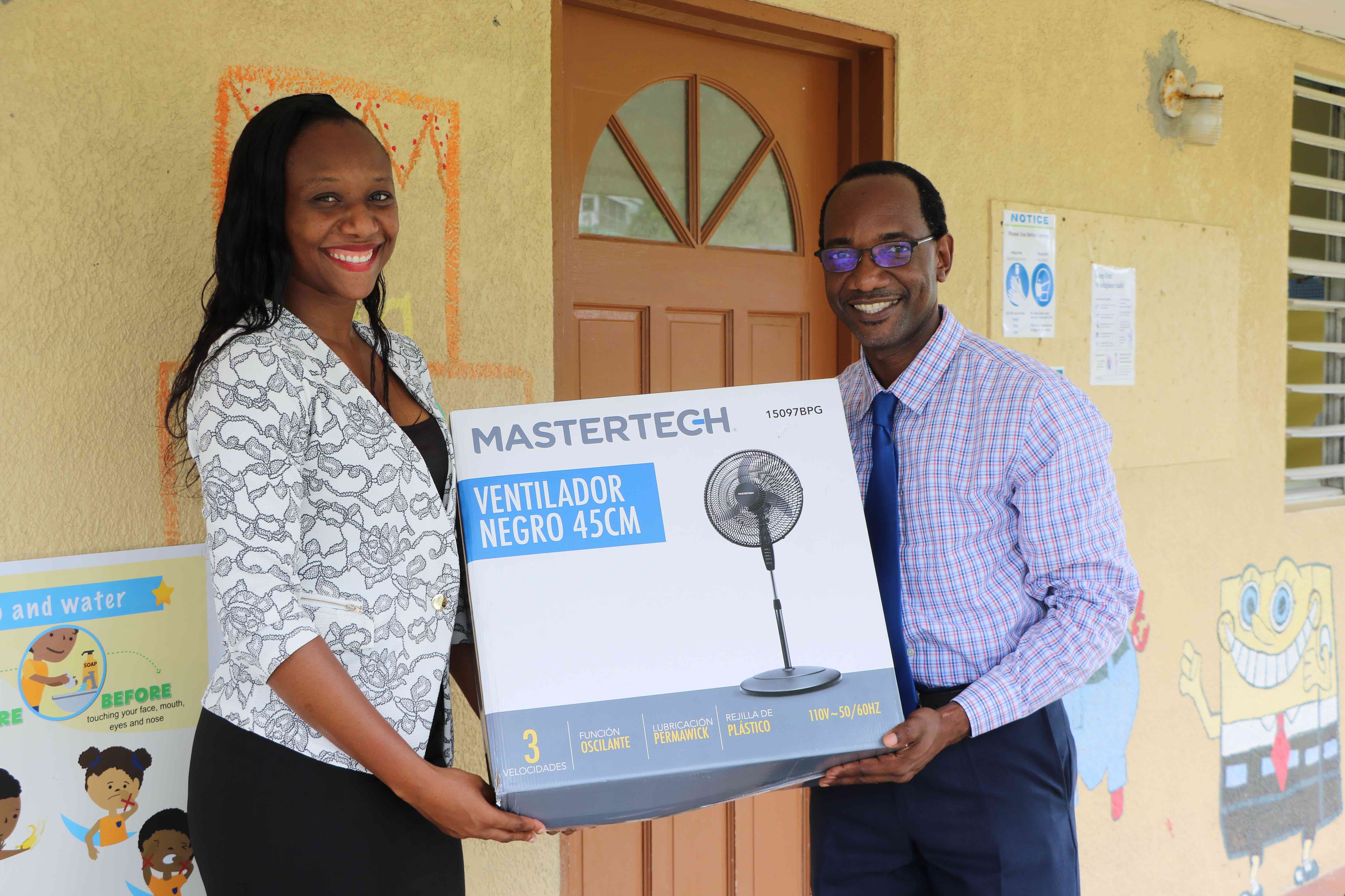 (l-r) – Ms. Latoya Jones (left), former student of the Inez France Pre School, presenting a gift of school supplies and equipment for the Inez France Pre School in the St. Thomas' Parish to Mr. Kevin Barrett, Permanent Secretary in the Ministry of Education on Nevis on September 30, 2020 while school Supervisor Ms. Monecia Clarke looks on