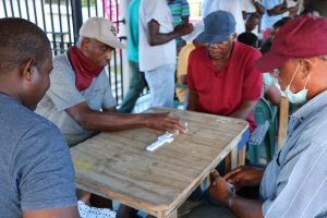 Patrons participate in a domino competition at World Food Day activities at the Cultural Village in Charlestown on October 16, 2020