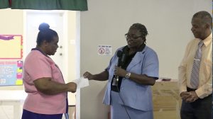 (l-r) Ms. Pamela Elliott, Supervisor of the Gingerland Preschool accepting a cheque from Ms. Dawnny Lanns, Education Officer responsible for the Gingerland Preschool donated by Hon. Eric Evelyn, Minister of Youth and Community Development in the Nevis Island Administration, and area representative for St. George’s, Gingerland on October 09, 2020, while Mr. Evelyn looks on