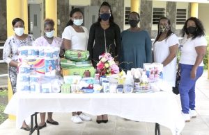 Members of the Concerned Citizens Movement Women’s Arm with their donation of personal care items to  residents of the Flamboyant Nursing Home with  Registered Nurse Kella Didier (third from left) who is attached to the Home 