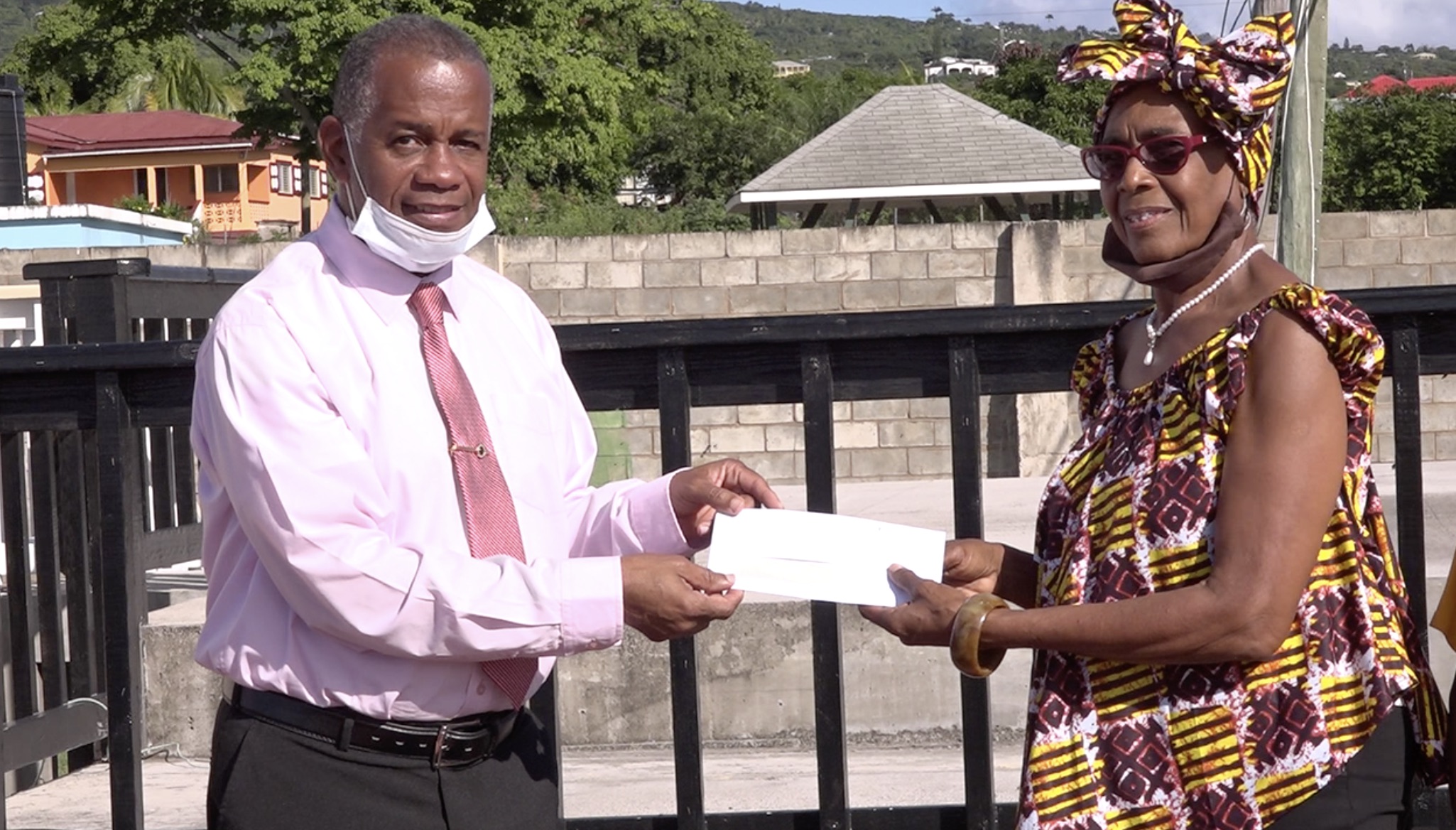 Hon. Eric Evelyn, Minister of Culture on Nevis accepting a monetary donation from Mrs. Gloria Anslyn, on behalf of the first Culturama Committee at the Cultural Complex in Charlestown on December 02, 2020