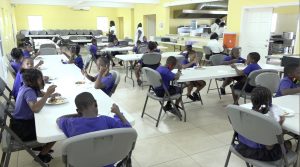 Students of the Joycelyn Liburd Primary School in Gingerland enjoying the national dish of Belize as part of the “Tour around the Caribbean” initiative introduced in the Department of Education’s School Meals Programme
