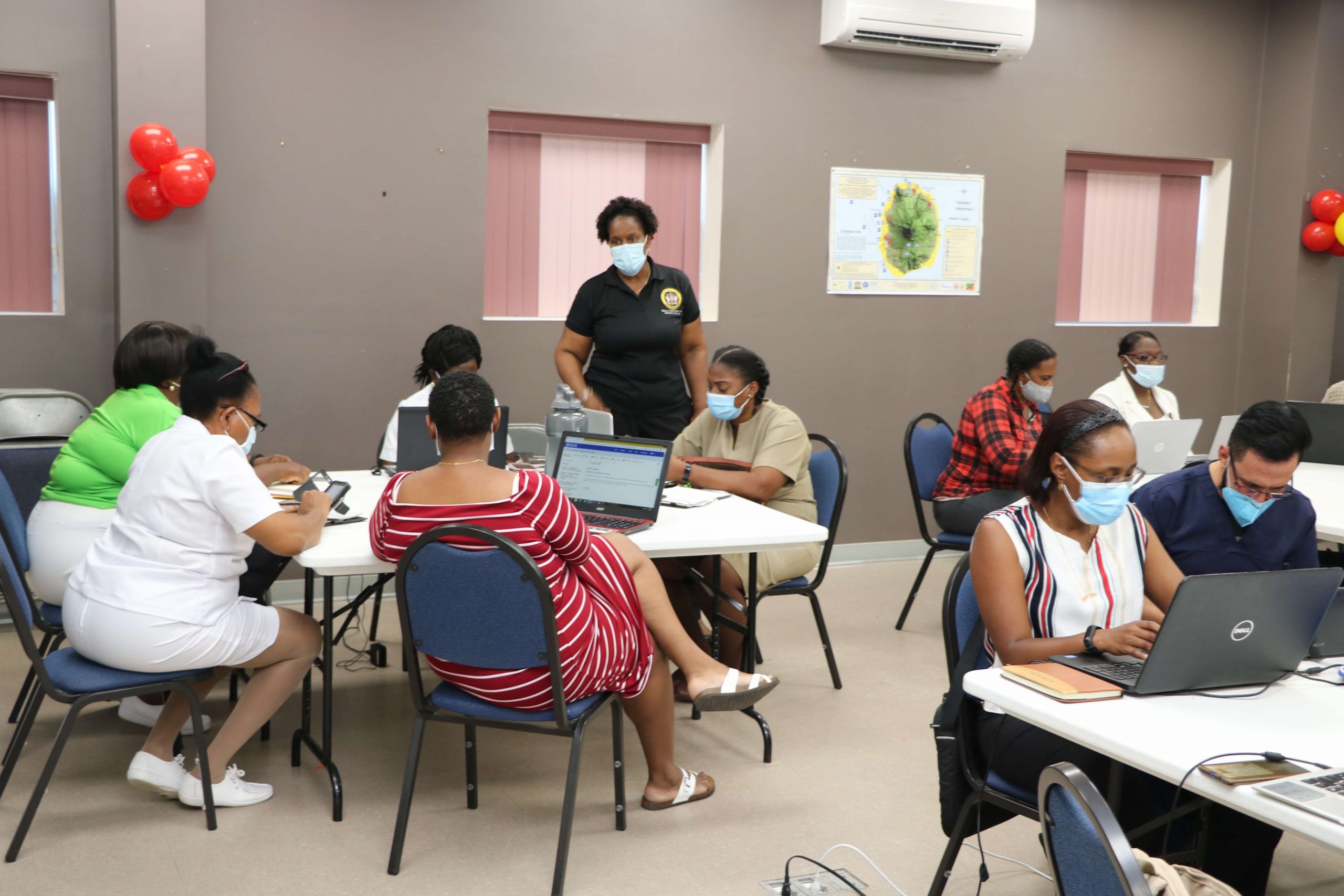 Dr. Judy Nisbett, Chair of the Nevis COVID-19 Task Force (standing) during the training session at the Disaster Management Department’s conference room on February 19, 2021, with health professionals on Nevis in preparation for administering the AstraZeneca-Oxford vaccine in the fight against COVID-19