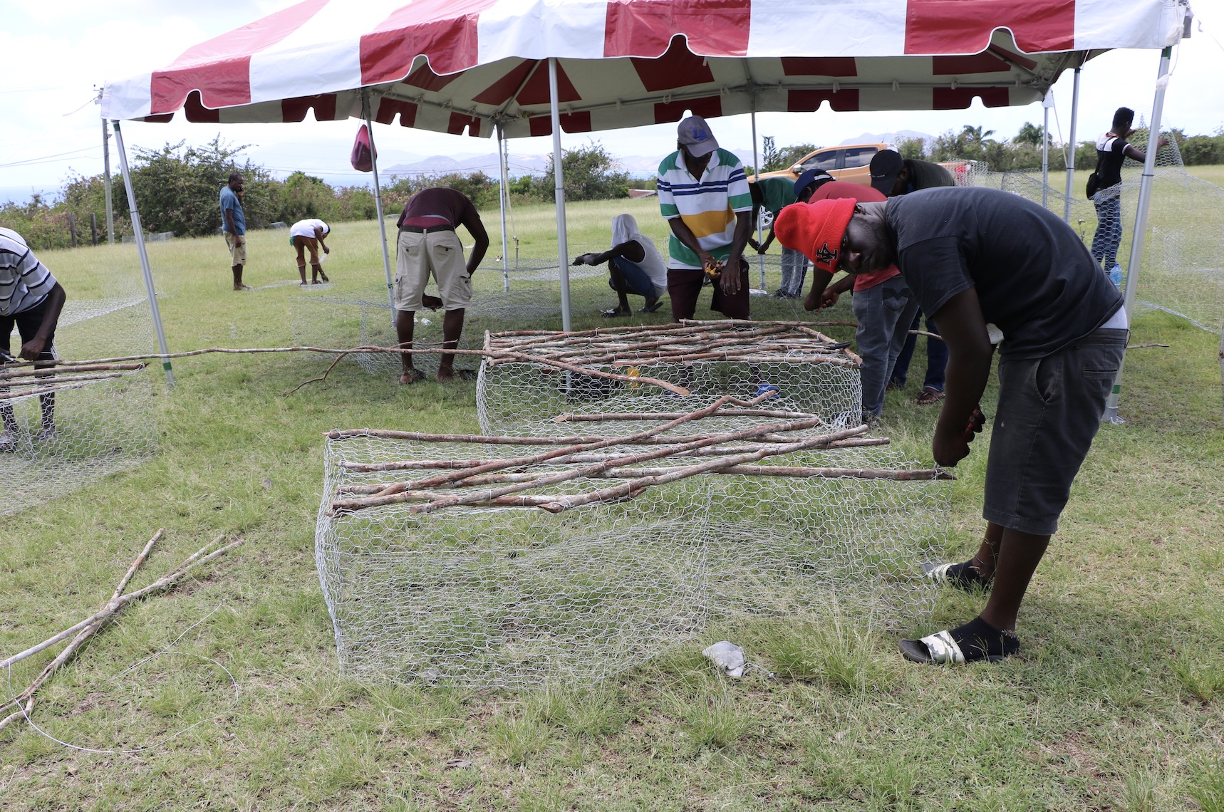 Participants constructing fish pots at the Department of Gender Affairs Fish Trap Making Workshop for boys and young men at the Jessups Playing Field on May 08, 2021