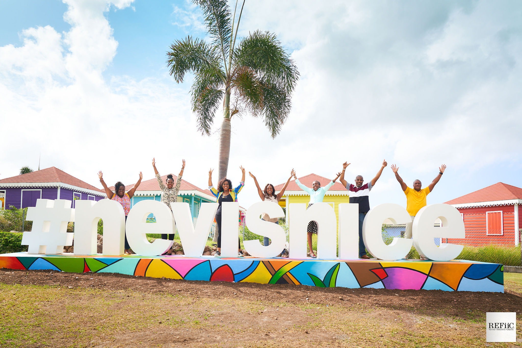 Nevis Tourism Authority staff taking photos with Ms. Jadine Yarde, the authority’s CEO (fourth from left) at the new #nevisnice fixture on the Island Main Road outside the Artisan Village at Pinney’s (photo provided)