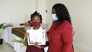 Khylinn Prentice of the Elizabeth Pemberton Primary School receives Naomi Daniel-Browne Scholarship Award from Mrs. Adina Taylor, sister of the late Naomi Daniel-Browne