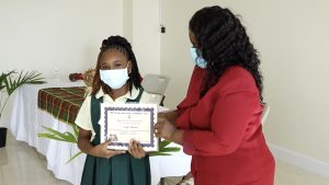 Seriah Laurent of the Ivor Walters Primary School receives Naomi Daniel-Browne Scholarship Award from Mrs. Adina Taylor, sister of the late Naomi Daniel-Browne