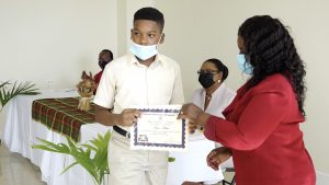 Kuwan Wilkin of the Charlestown Primary School receives Naomi Daniel-Browne scholarship award from Mrs. Adina Taylor, sister of the late Naomi Daniel-Browne 