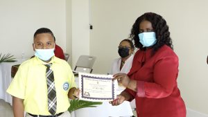 D’Mari Myers of the Violet O. Jeffers-Nicholls Primary School receives Naomi Daniel-Browne scholarship award from Mrs. Adina Taylor, sister of the late Naomi Daniel-Browne