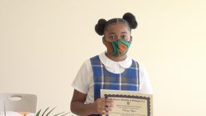 T’shanzi Taylor of the St. James’ Primary School after receiving her Naomi Daniel-Browne scholarship award from Mrs. Adina Taylor, sister of the late Naomi Daniel-Browne