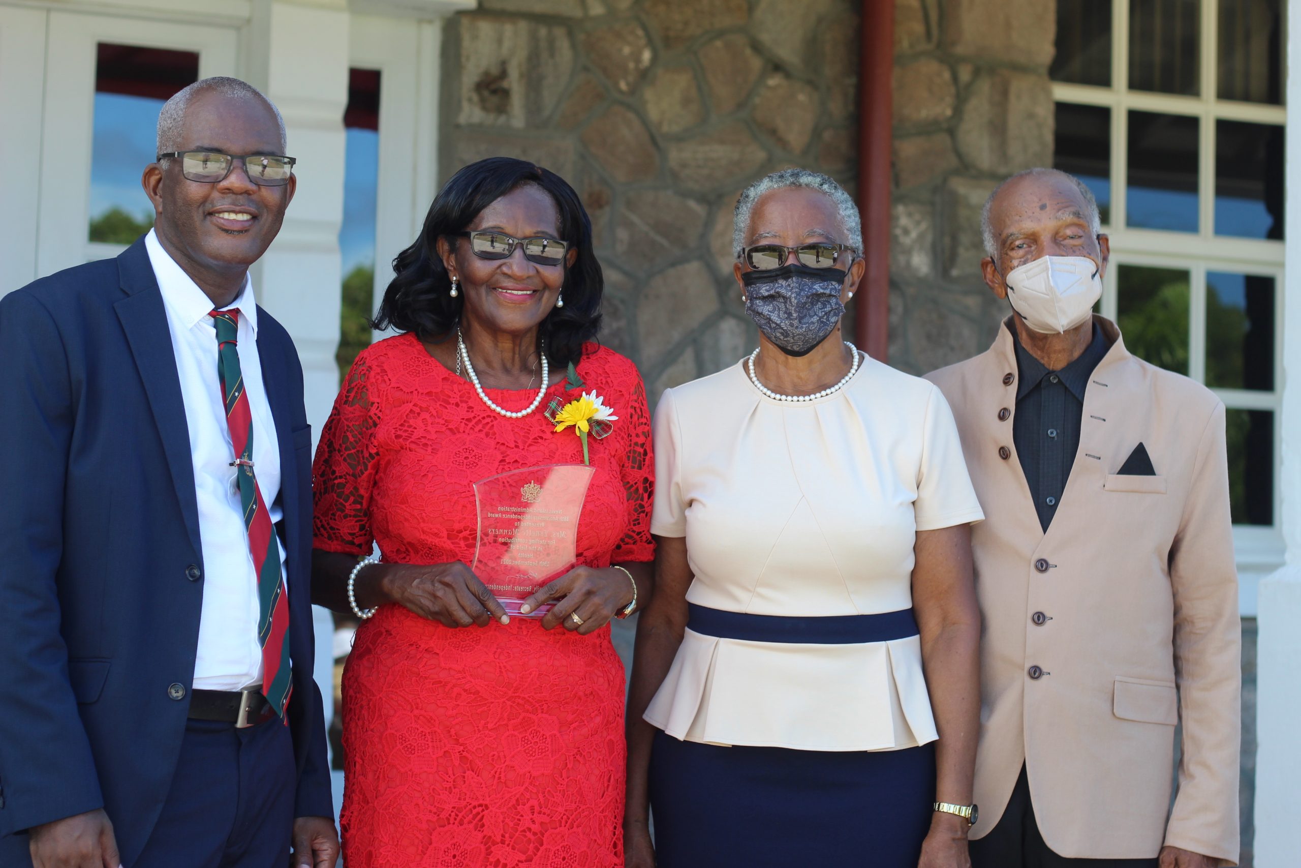 Independence Day honouree retired registered nurse Mrs. Ernette Manners (second from left) showing off her award flanked by her brother Mr. Oral Brandy (left) and Her Honour Mrs. Hyleeta Liburd, Deputy Governor General on Nevis, (second from right) and her husband following an awards ceremony at Government House on September 20, 2021