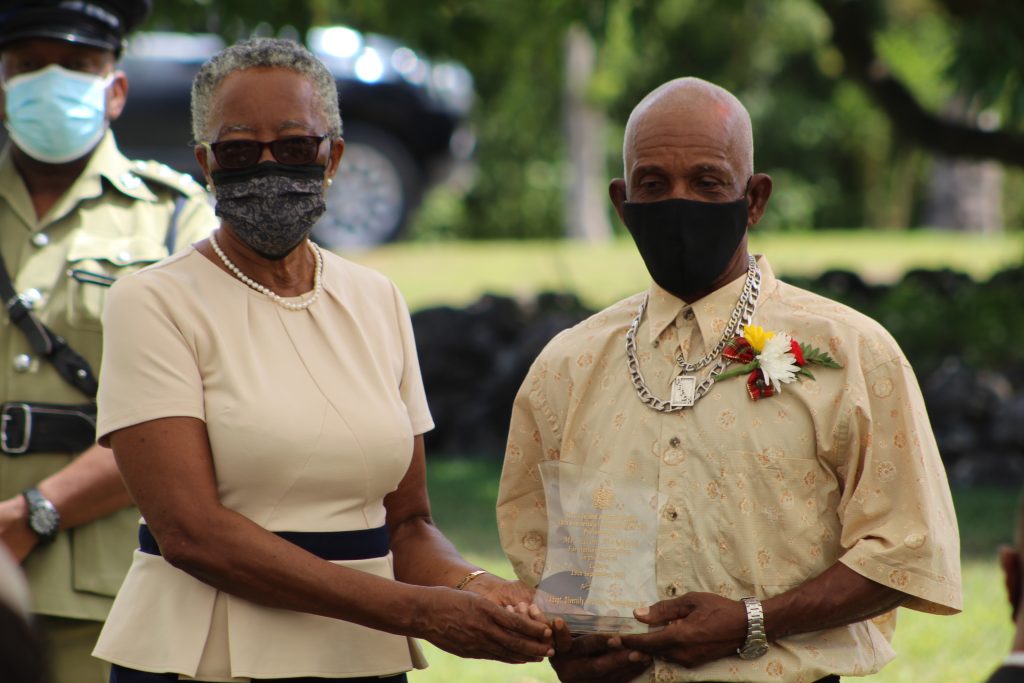 Her Honour Mrs. Hyleeta Liburd, Deputy Governor General in Nevis presenting a plaque to Mr. Orville Hendrickson on behalf of Independence Day honoree Mr. Elton Archibald for his contribution to Culture at an Awards Ceremony at Government House on September 20, 2021, on the occasion of the 38th Anniversary of the Independence of St. Christopher and Nevis