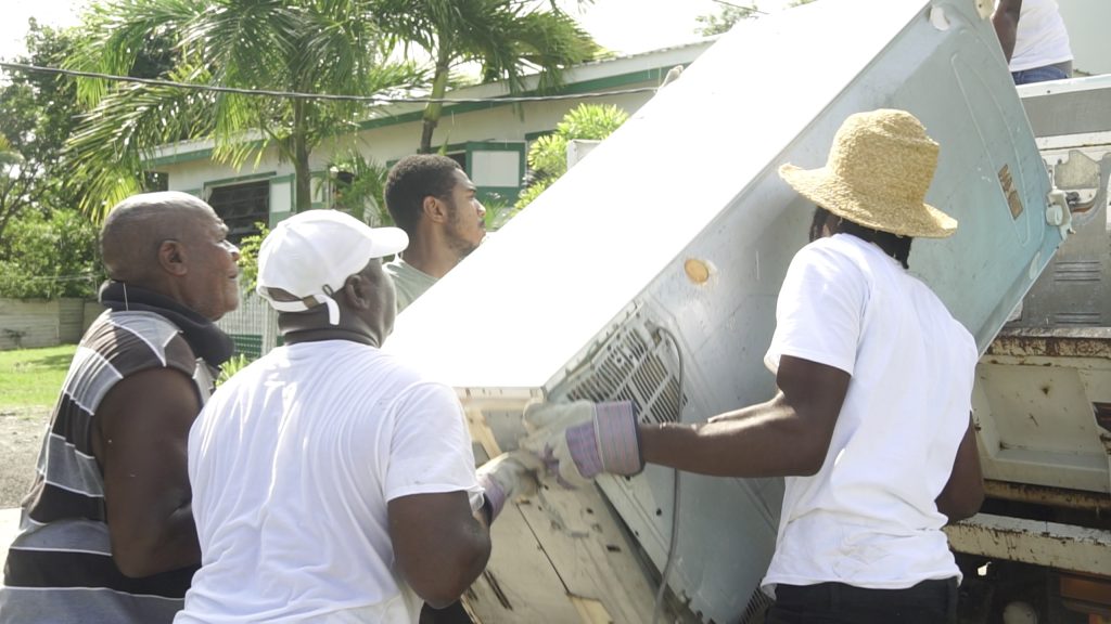 Hon. Alexis Jeffers, Area Representative for St. James’ Parish, helps to load white goods onto a truck with the help of constituents of the St. James’ Parish for disposal at the Long Point landfill during a clean-up exercise on October 16, 2021, in celebration of the 10th anniversary of his election to the Nevis Island Assembly