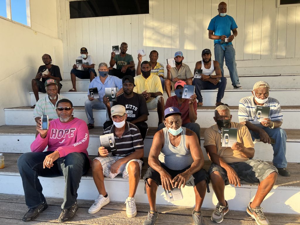 Some of the 55 fishers on Nevis showing off the hand-held Global Positioning Devices donated to them by the Ministry of Marine Resources with training facilitator Captain Frankie Tyson (front row extreme left), owner of SKN Executive Travel after the handing over ceremony at the Elquemedo T. Willett Park in Charlestown on December 20, 2021