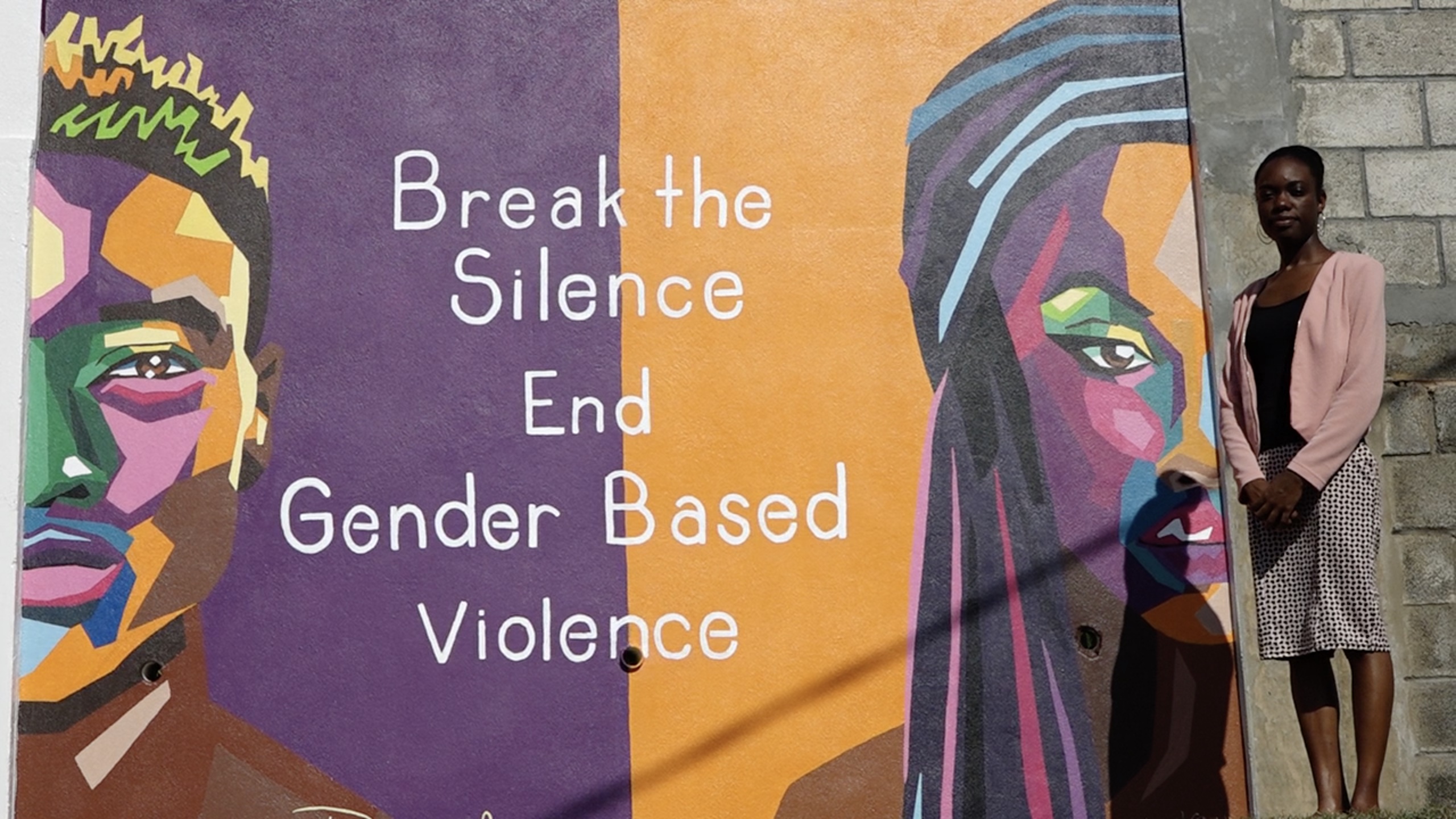 Artist Danielle Moore with her painting in Gingerland commissioned by the Ministry of Health and Gender Affairs on Nevis in its fight against gender-based violence campaign