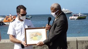 (L-r) Staff Captain Daniel of the MV World Voyager receiving a copy of a historic old map of Nevis from Hon. Spencer Brand who is representing Hon. Mark Brantley, Premier of Nevis and Minister of Tourism, as a token of appreciation at a welcoming ceremony at the Charlestown Port during the vessel’s inaugural call to Nevis on December 17, 2021