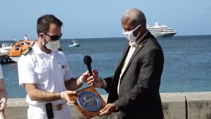 (L-r) Staff Captain Daniel of the MV World Voyager presents a plaque to Hon. Spencer Brand who is representing Hon. Mark Brantley, Premier of Nevis and Minister of Tourism, as a token of appreciation at a welcoming ceremony at the Charlestown Port during the vessel’s inaugural call to Nevis on December 17, 2021
