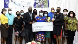 Ms. Zahnela Claxton, Principal Education Officer in the Department of Education (third from right), and Mr. Carlisle Powell representative for the Dr. Lornette Mills Charitable Foundation (fifth from left), with school principals and Education Officers at a handing over ceremony on February 24, 2022, at the Jessups Community Centre