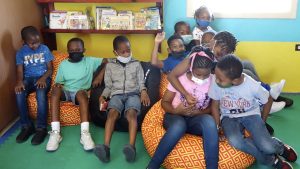 Excited students of the St. James Primary School sample the bean bag experience at the school’s library, a gift from the Butlers Enhancement and Improvement Association on February 04, 2022