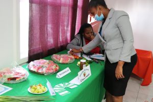 Ms. Latoya Jeffers, Assistant Secretary in the Ministry of Health and Gender Affairs sampling fruits form a participant at the 1st Small Business Boot Camp in 2020 (file photo)