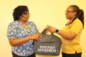 Ms. Karen McDonald, of the Department of Statistics on Nevis and field supervisor for the Population and Housing Census 2021, hands over a census kit on April 20, 2022, to Mrs. Lisa Pestano-Browne, enumerator and supervisor for Fountain Village