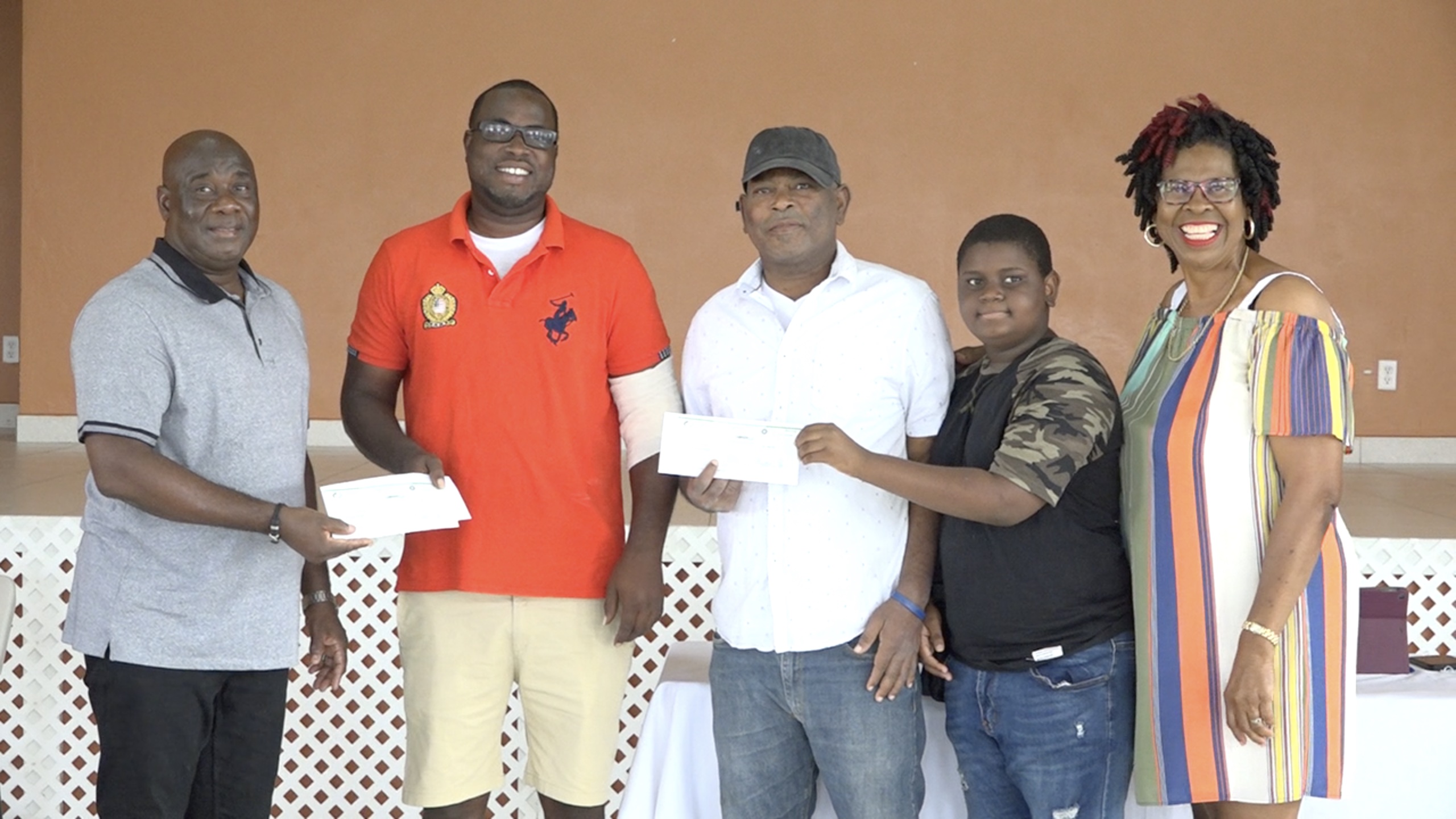 Dialysis patients from the St. James Parish Mr. Lester Pemberton (second from right) and Mr. Fitzroy Warner accompanied by his son (third from right) with Hon. Alexis Jeffers, Area Representative (extreme left); and Ms. Leonne Jeffers, representative of the Brick Kiln Community Group moments after they are presented with a cheque from members of the community to assist with medical expenses