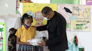 Hon. Mark Brantley, Premier of Nevis and Minister of Tourism, presents Jaquoiya Francis of the Cecele Browne Integrated School with gifts for placing second in the Ministry of Tourism’s 2022 Environmental Poster Contest