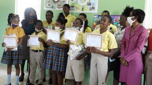 Students of the Cecele Browne Integrated School, participants in the Ministry of Tourism’s 2022 Environmental Poster Contest with tourism officials (right) and Mrs. Jennifer Liburd, teacher at the school (left)