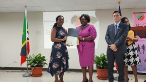 Hon. Hazel Brandy-Williams, Jr. Minister of Gender Affairs, presenting an award to Ms. Tessa Nicholas while His Excellency Michael Lin, Resident Ambassador of the Republic of China (Taiwan) to St. Kitts and Nevis, and Ms. Latoya Jeffers, Assistant Secretary in the Ministry of Health and Gender Affairs look on