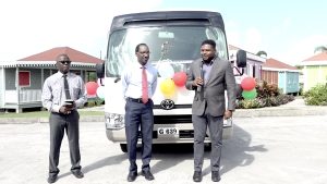 (L-r) Pastor Bernard Browne; and Mr. Kevin Barrett, Permanent Secretary in the Ministry of Education, with Hon. Troy Liburd, Jr. Minister of Education in Nevis, while commissioning the Toyota Coaster bus in the background at the Artisan Village at Pinney’s Estate on November 01, 2022