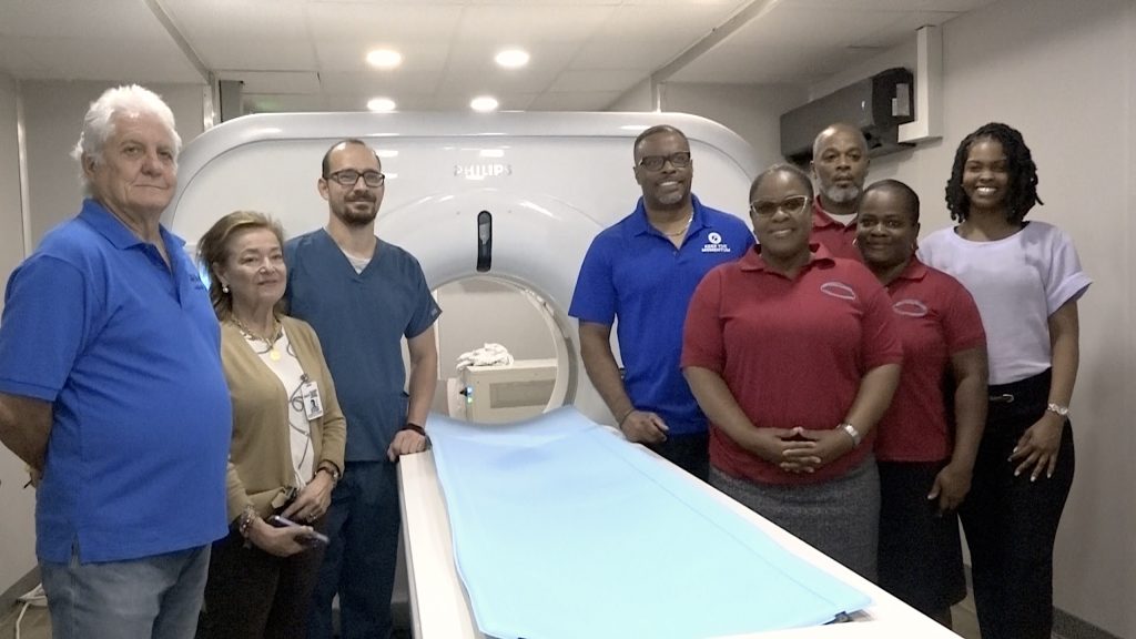 Hon. Mark Brantley, Premier of Nevis and Minister of Health (back right - blue shirt), next to the new state-of-the-art Philips computerized tomography (CT) scan installed at the Alexandra Hospital, flanked by Mr. Gary Pemberton, Hospital Administrator; and (first row - r-l) Mrs. Shinnelle Browne, Assistant Administrator; and Radiographers Mrs. Karema David and Ms. Carrie Bussue. (Back left – r-l) Mr. Daniel Docio, Customer Support Engineer for IMX; Ms. Clarita Posada, IMX Product Sales Specialist; and Mr. Jairo Güiza, Clinical Applications Specialist at Alexandra Hospital on December 02, 2022