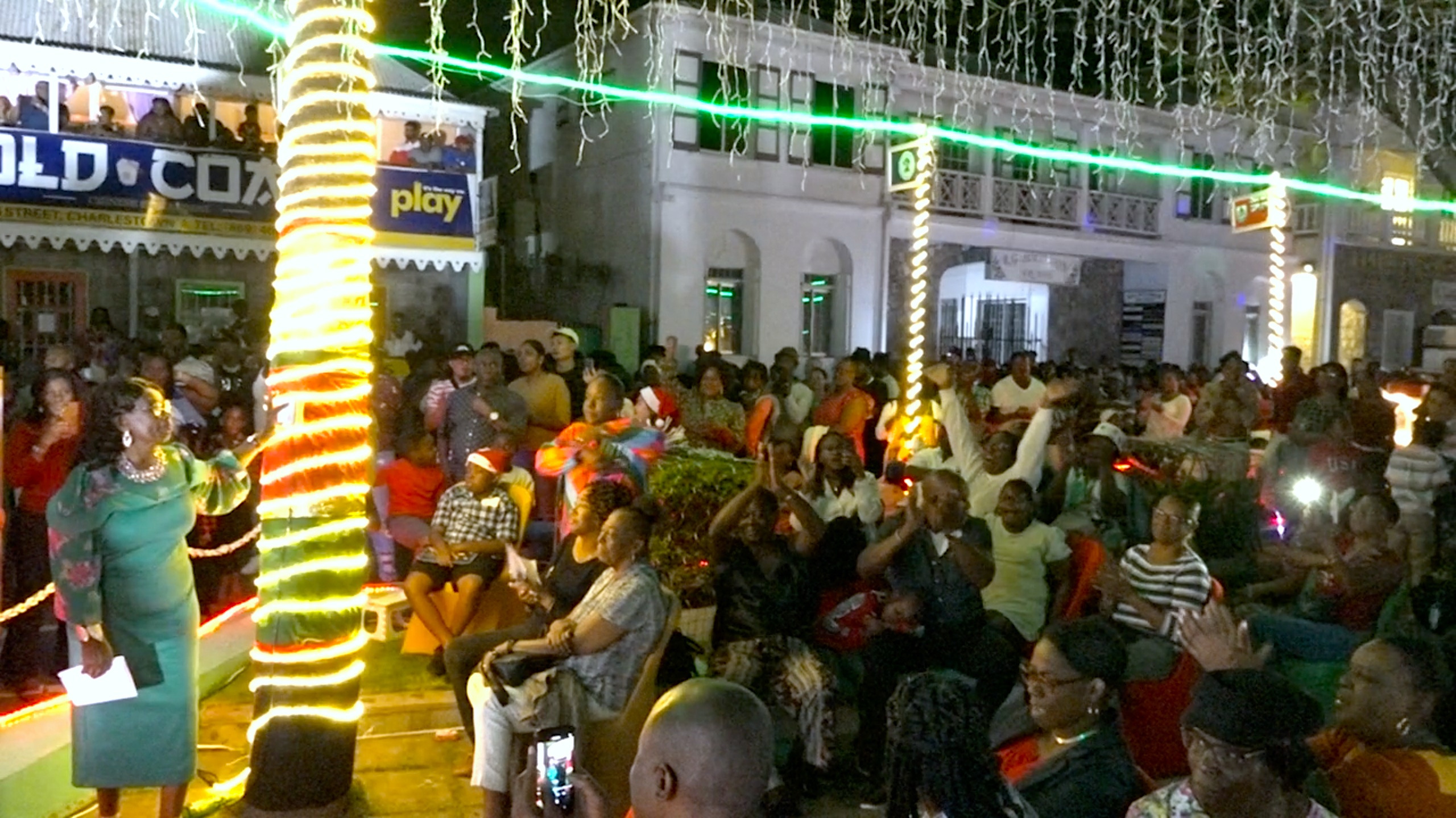 Ms. Earlene Maynard, Patron for the Department of Community Development’s annual Christmas Tree Lighting at the War Memorial in Charlestown on December 07, 2022, flicks the switch to herald in the Christmas cheer to the delight of hundreds of patrons