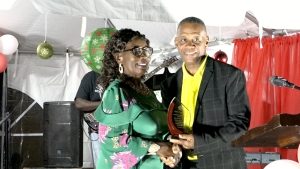 Hon. Eric Evelyn, Minister of Community Development, presents Ms. Earlene Maynard, Patron of the Department of Community Development’s annual Christmas Tree Lighting Ceremony at the War Memorial in Charlestown with a plaque of appreciation on December 07, 2022