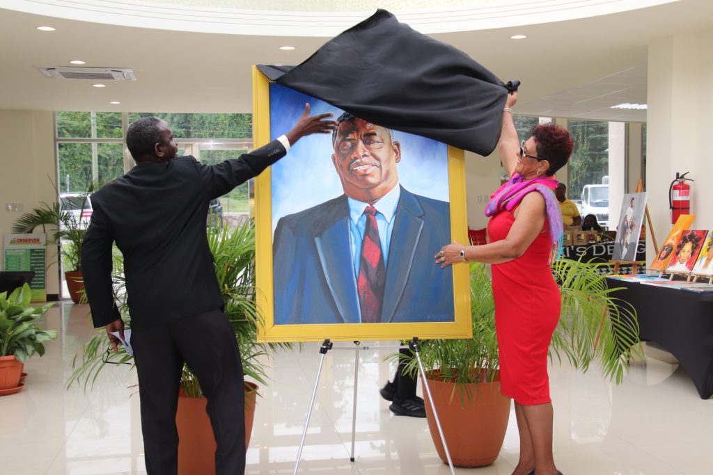 (L-r) Mr. John Hanley, Permanent Secretary in the Ministry of Tourism on Nevis, assisting Mrs. Yvonne Guishard, widow of the late Hon. Malcolm Guishard, former Deputy Premier of Nevis and Minister of Tourism, patron of the Malcolm Guishard Recreational Park, with the unveiling of his portrait on his birthdate on January 16, 2023, at the Visitor Centre