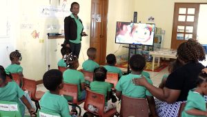Ms. Monecia Clarke, Supervisor of the Inez France Preschool turns on a 42-inch Samsung smart television on a mobile stand for students presented to her on behalf of the school by Hon. Troy Liburd, Minister of Education on Nevis, on February 10, 2023