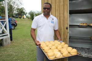 Hon. Mark Brantley, Premier of Nevis and Minister of Tourism with traditional bread baked in a traditional box oven in the background at the Nevisian Heritage Village in Gingerland at a Heritage Day activity in 2017 (file photo)