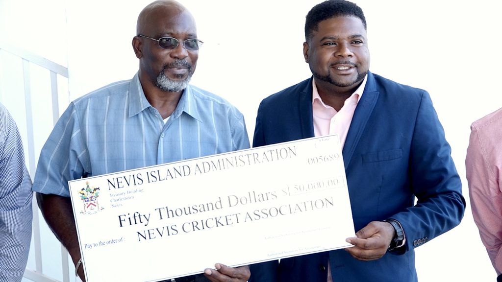 Hon. Troy Liburd, Minister of Sports in the Nevis Island Administration (r), presenting a $50,000 cheque to Mr. Carlisle Powell, President of the Nevis Cricket Association, on March 01, 2023, for a gala on March 09, 2023, in honour of Elquemedo T. Willett for his historic cricketing accomplishment 50 years ago