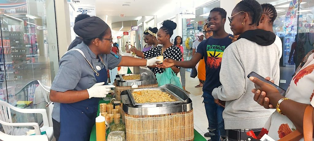 Members of team Barbados serving samples of Nevis cuisine to members of the public at the Sheraton Mall in Barbados on May 12, 2023